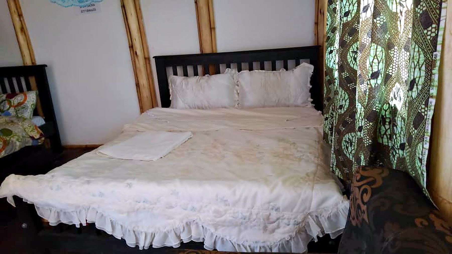 Double bed dressed in white linen in a cottage room