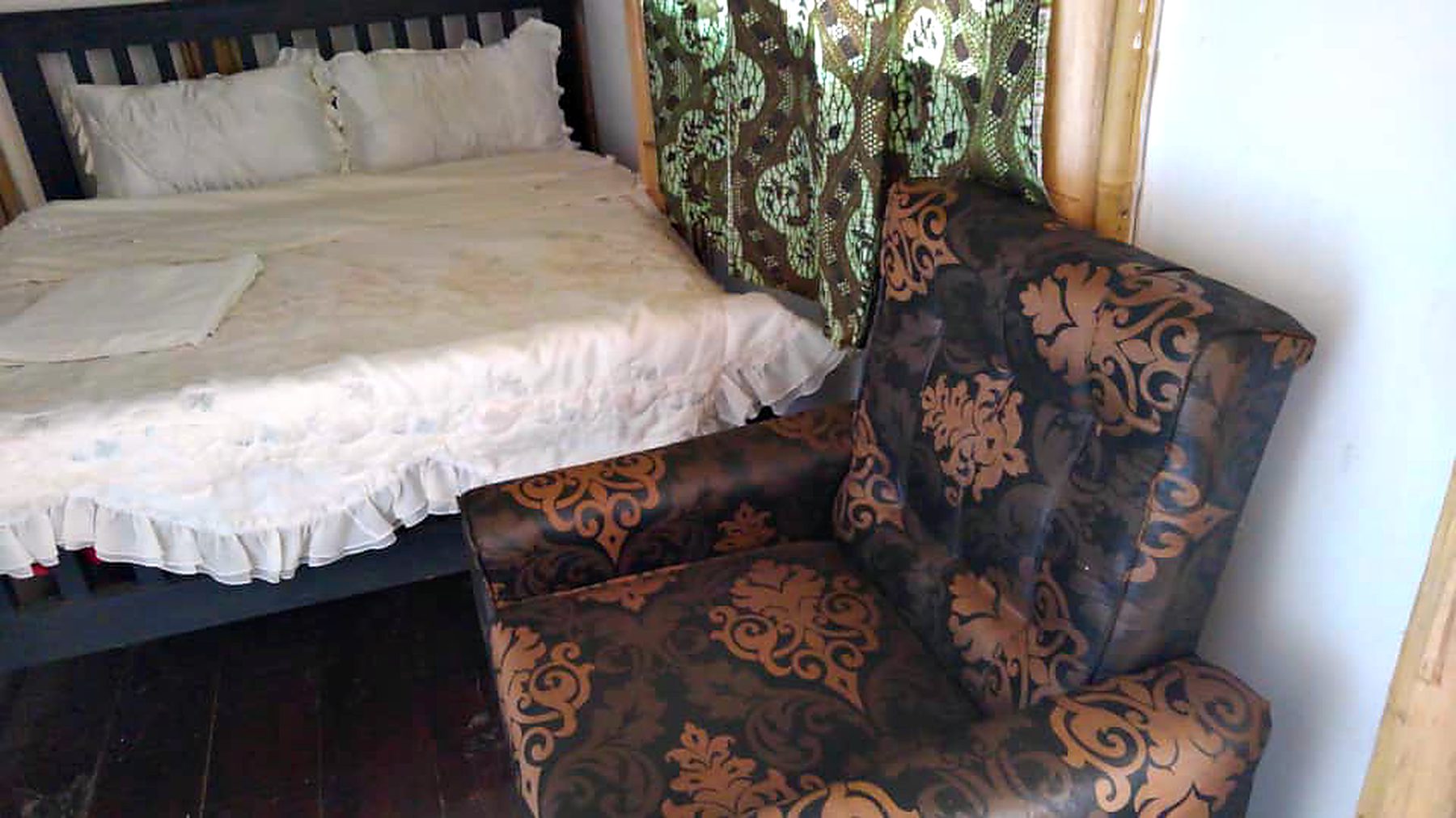 An armchair beside the bed in a guest room